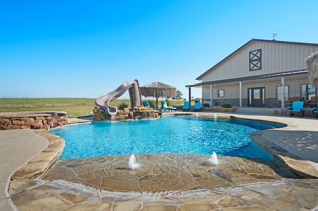 view of swimming pool featuring pool water feature, a patio, and a water slide