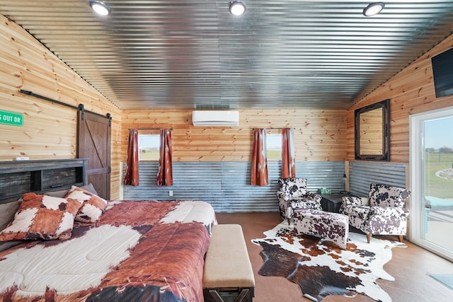 bedroom with vaulted ceiling, access to outside, a barn door, wooden walls, and a wall mounted air conditioner