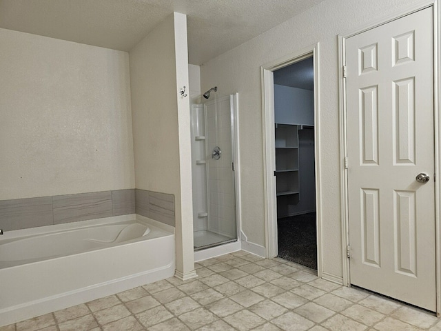 bathroom featuring plus walk in shower and a textured ceiling