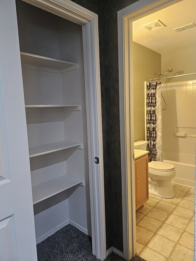 full bathroom with shower / bath combination with curtain, vanity, and toilet