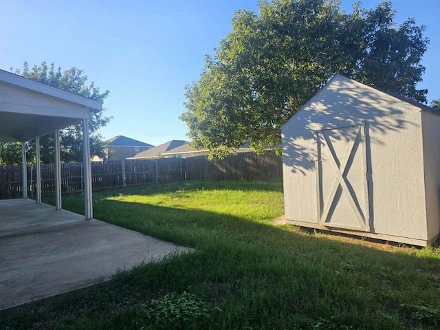 view of yard with a storage shed and a patio area