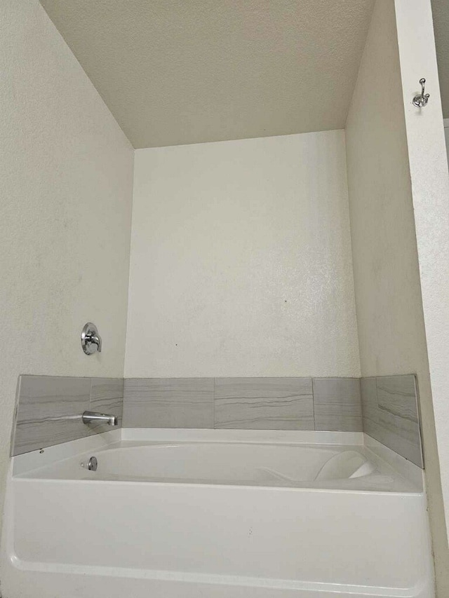 bathroom featuring a washtub and a textured ceiling