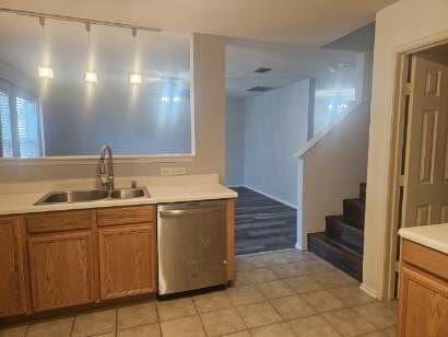 kitchen with dishwasher, light tile patterned floors, and sink