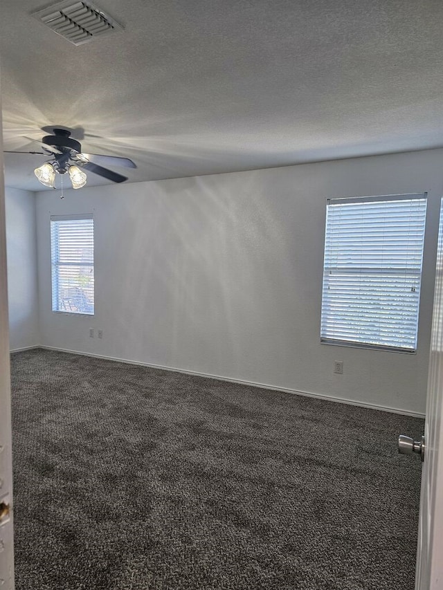 carpeted spare room with a textured ceiling and ceiling fan