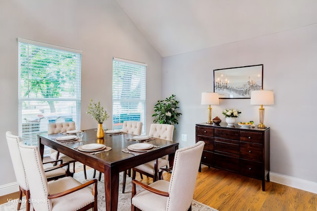 dining area featuring light hardwood / wood-style flooring and high vaulted ceiling