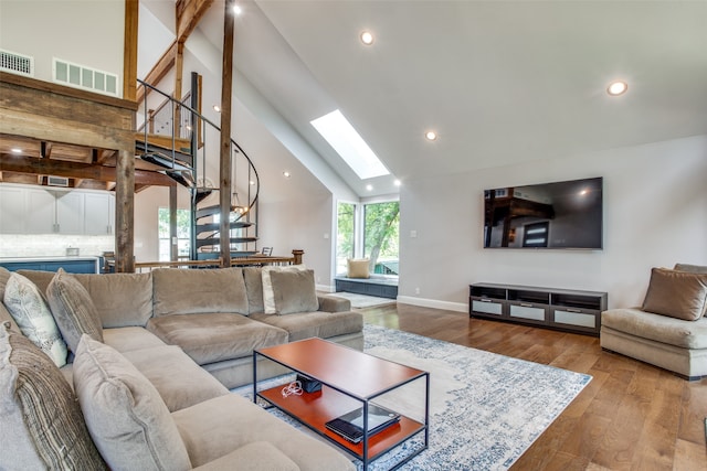 living room featuring beamed ceiling, hardwood / wood-style floors, high vaulted ceiling, and a skylight