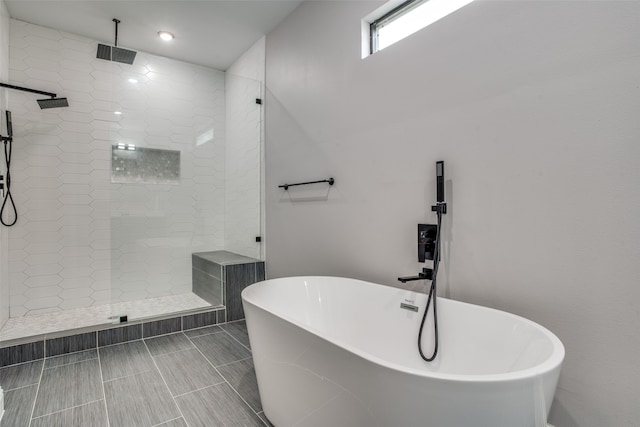 bathroom featuring shower with separate bathtub