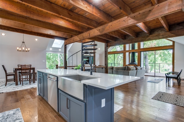 kitchen with dark wood-type flooring, decorative light fixtures, wooden ceiling, and an island with sink