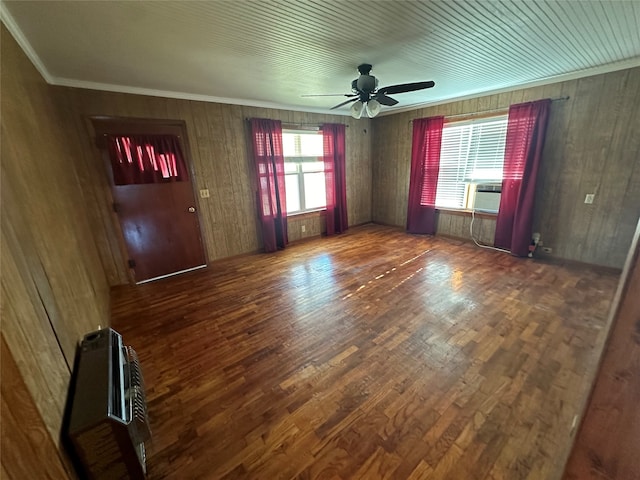 unfurnished room featuring wood walls, ceiling fan, dark hardwood / wood-style floors, and plenty of natural light