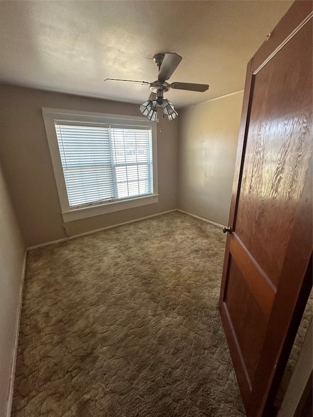 unfurnished room with dark carpet, a textured ceiling, and ceiling fan