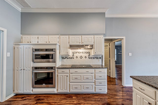 kitchen featuring dark stone countertops, black electric cooktop, double oven, decorative backsplash, and white cabinets