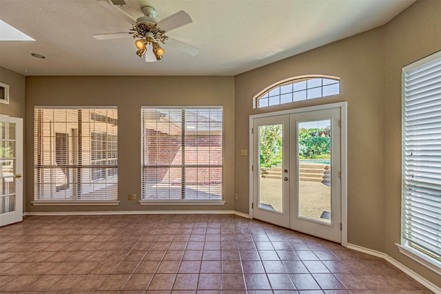 entryway with light tile patterned floors, ceiling fan, and french doors