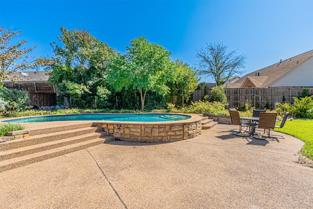 view of swimming pool featuring a hot tub and a patio area