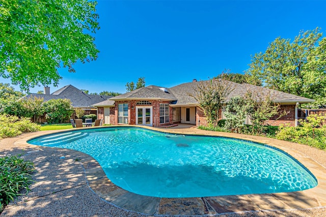 view of swimming pool featuring a patio and french doors