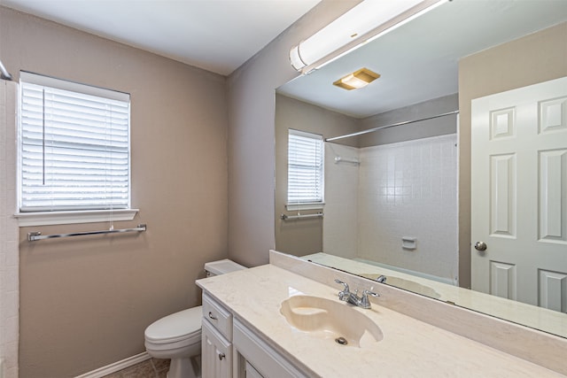 bathroom featuring vanity, tile patterned flooring, toilet, and tiled shower