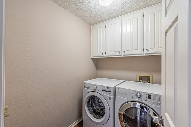 laundry room featuring cabinets, a textured ceiling, and independent washer and dryer