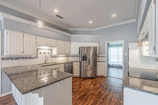 kitchen featuring appliances with stainless steel finishes, white cabinetry, sink, dark stone counters, and kitchen peninsula