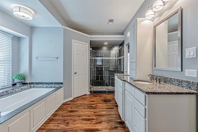 bathroom with shower with separate bathtub, wood-type flooring, and vanity