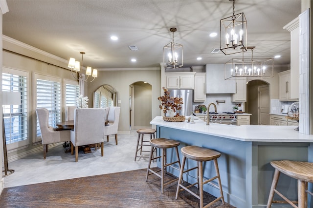 kitchen with crown molding, a breakfast bar area, pendant lighting, and stainless steel appliances