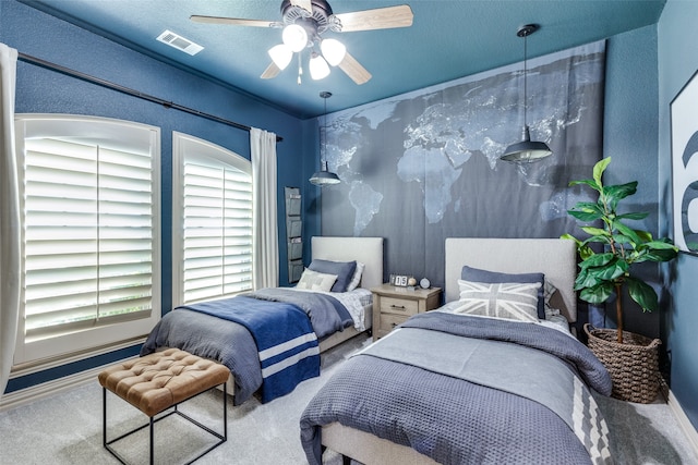 carpeted bedroom with ceiling fan and a textured ceiling