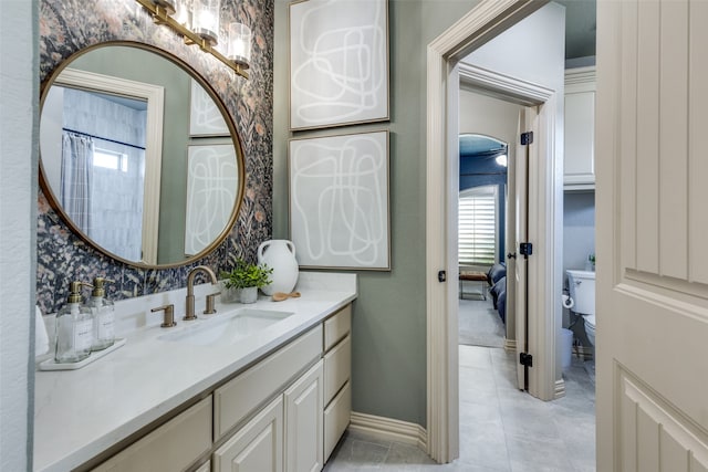 bathroom featuring a healthy amount of sunlight, vanity, toilet, and tile patterned floors