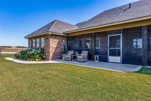 back of house with a sunroom, a yard, and a patio