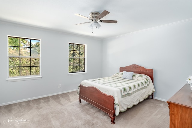 carpeted bedroom featuring multiple windows, ceiling fan, and crown molding