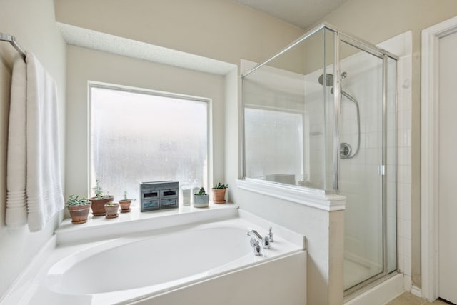 bathroom with plus walk in shower and a textured ceiling