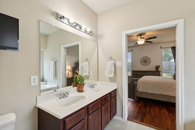 bathroom featuring ceiling fan, vanity, a textured ceiling, and hardwood / wood-style flooring