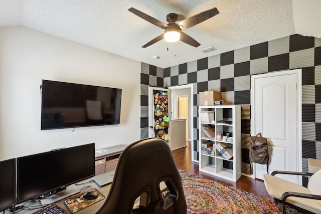 bedroom featuring dark wood-type flooring, vaulted ceiling, ceiling fan, a textured ceiling, and a closet