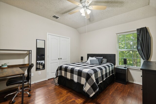 bedroom with dark hardwood / wood-style flooring, a textured ceiling, ceiling fan, and lofted ceiling