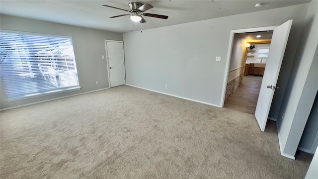 unfurnished room featuring ceiling fan and light carpet