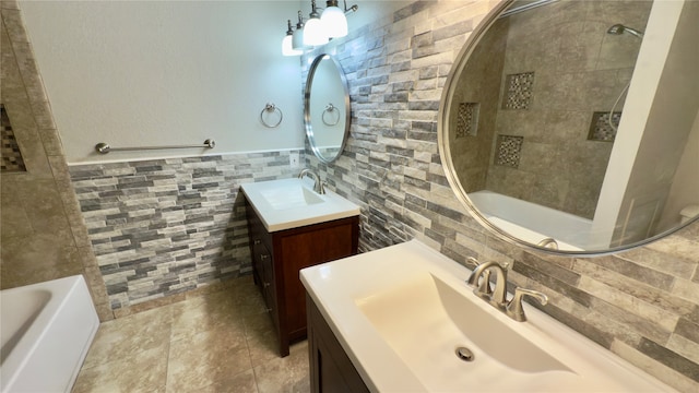 bathroom featuring tiled shower / bath combo and vanity