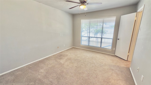 unfurnished room with ceiling fan and light colored carpet