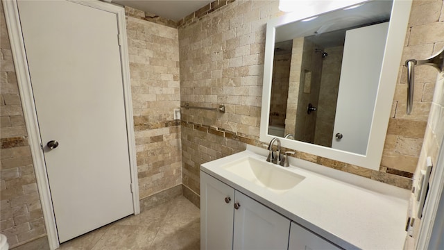 bathroom with tile patterned floors, vanity, and tiled shower