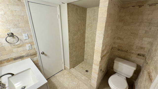 bathroom with vanity, tile patterned flooring, toilet, and tiled shower