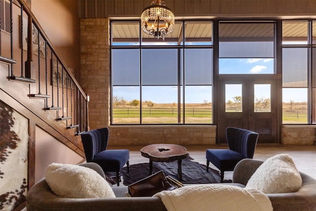 interior space featuring hardwood / wood-style floors, a towering ceiling, a chandelier, and a rural view