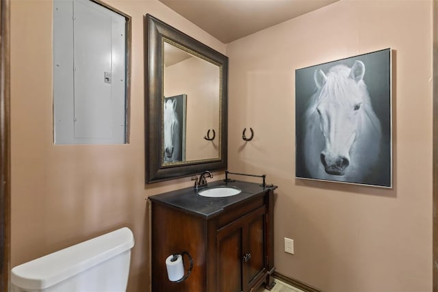 bathroom with vanity, toilet, and electric panel