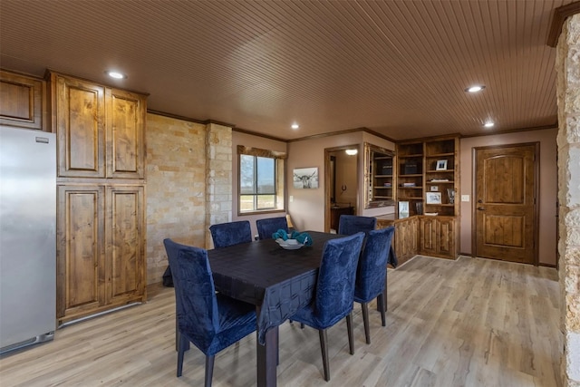 dining room with wood ceiling, light wood-type flooring, and crown molding