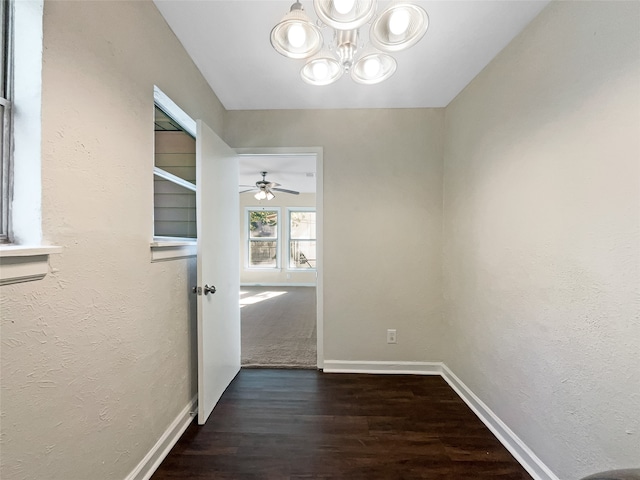 corridor with a notable chandelier and dark hardwood / wood-style flooring