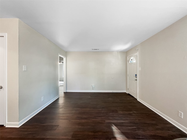 empty room with dark hardwood / wood-style flooring