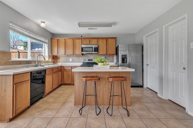 6001 Red Drum Dr, Fort Worth, TX 76179 - kitchen featuring stainless steel appliances, a center island, light tile patterned flooring, and light countertops