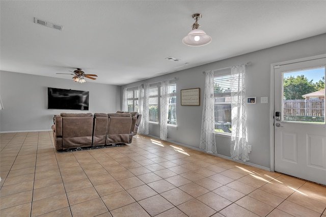 tiled living room with ceiling fan and plenty of natural light