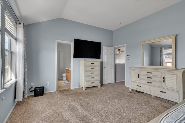 carpeted bedroom featuring lofted ceiling and ensuite bath