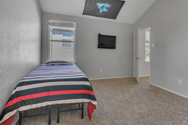 bedroom featuring lofted ceiling, multiple windows, and carpet flooring