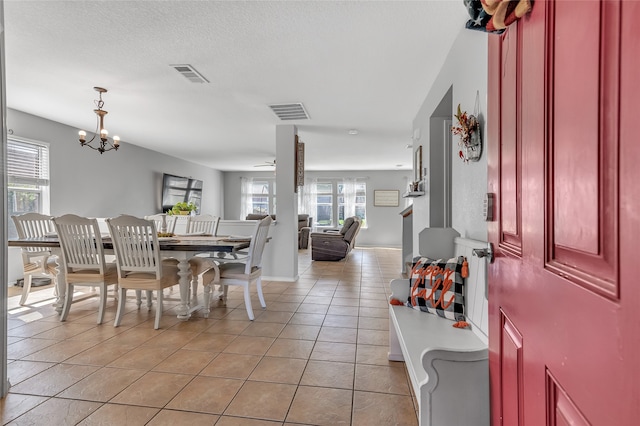 dining area featuring ceiling fan with notable chandelier and light tile patterned floors