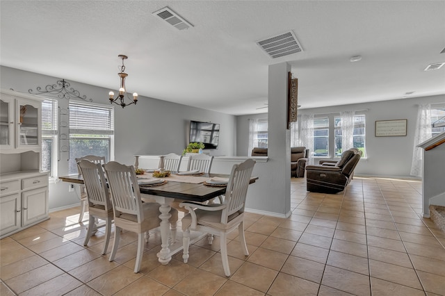 tiled dining space featuring a chandelier