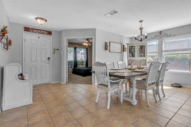 dining area featuring ceiling fan with notable chandelier and light tile patterned floors