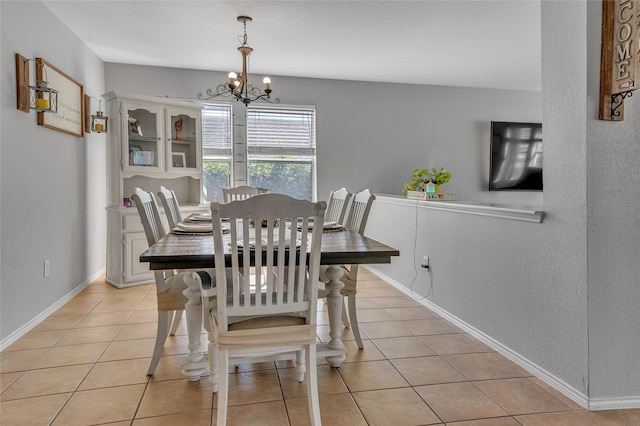 tiled dining space featuring a chandelier