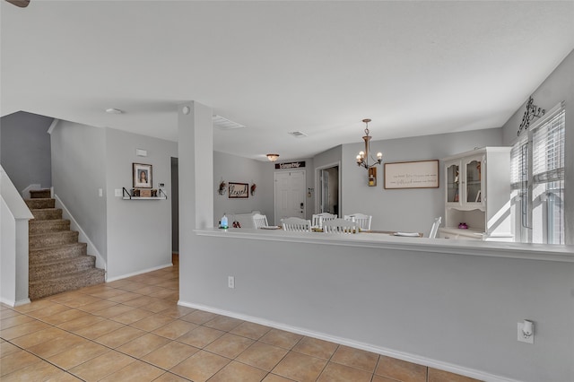 interior space featuring light tile patterned floors and a chandelier